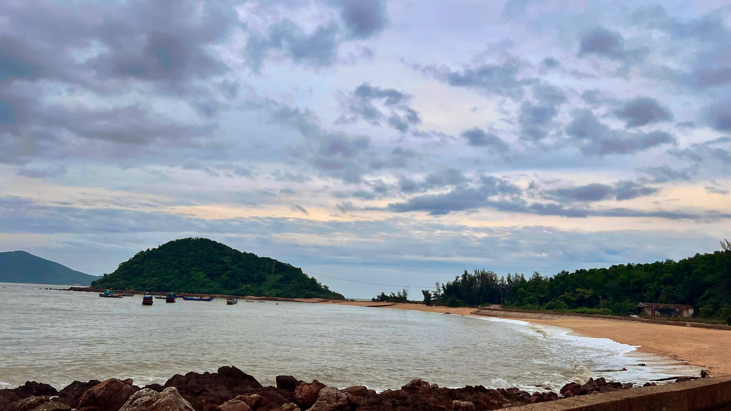 Bãi biển đảo Cái Chiên hoang sơ với rặng phi lao và thuyền cá lúc hoàng hôn